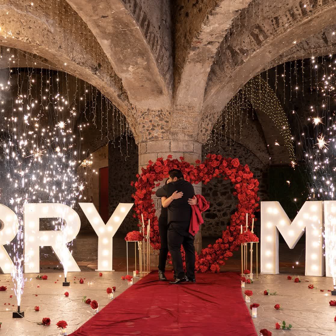 Pedida de matrimonio MARRY ME con corazón de rosas rojas bajo bóveda de cantera